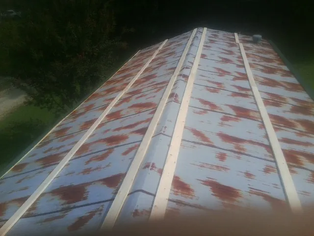 Rusted metal roof panels with new wood purlins before replacement — Storm Damage Roof Repair in East Palatka by Roofing Brothers