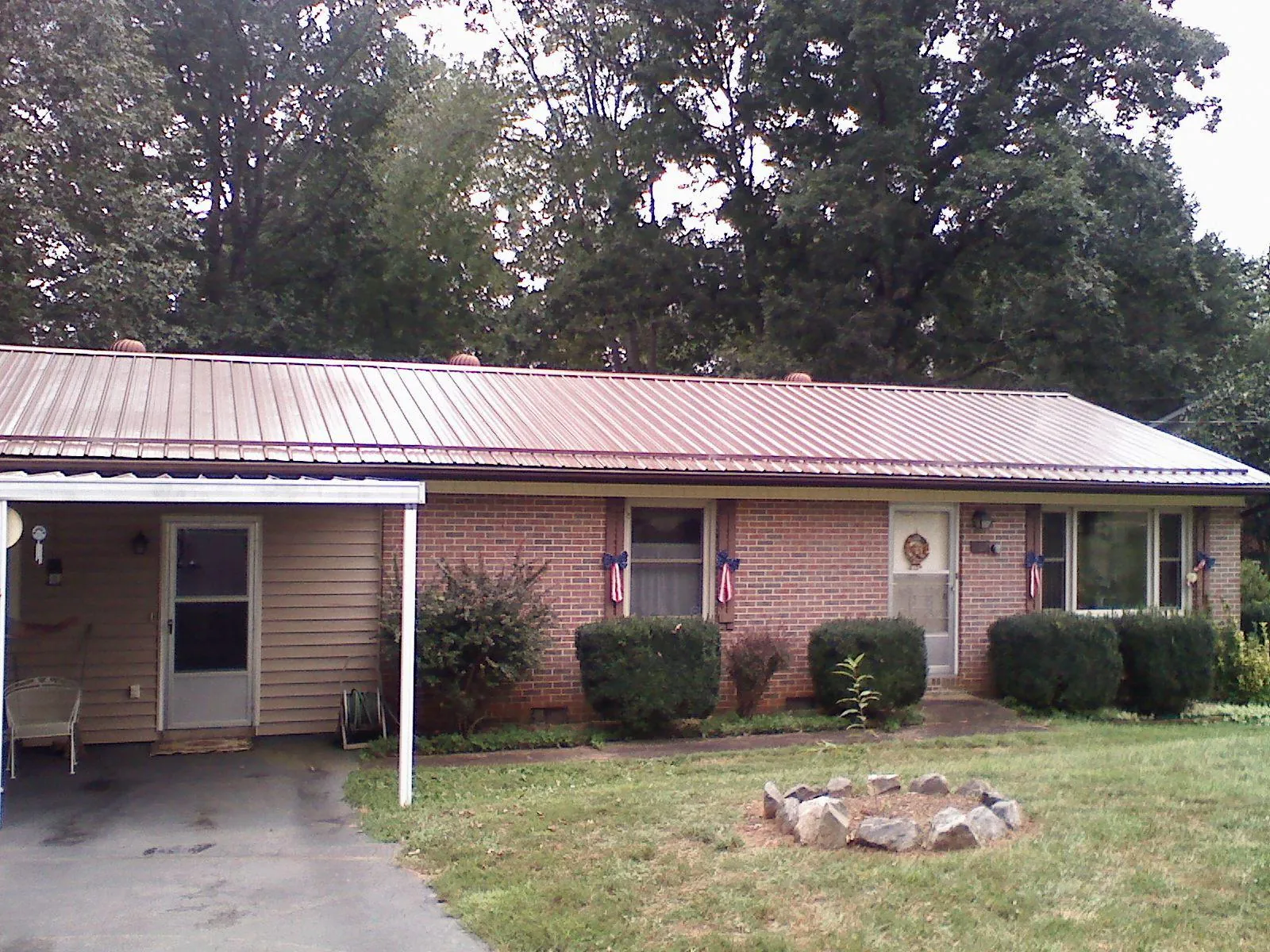 Bronze metal roof and carport on a brick ranch home — Roof Repair work by our crew in East Palatka